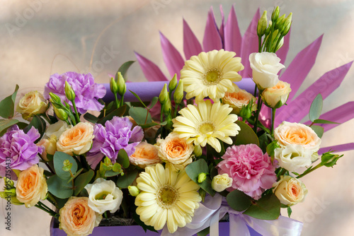 Tableau sur toile Bouquet of assorted flowers rests gracefully in a luxurious purple box, showcasing a blend of colors and textures