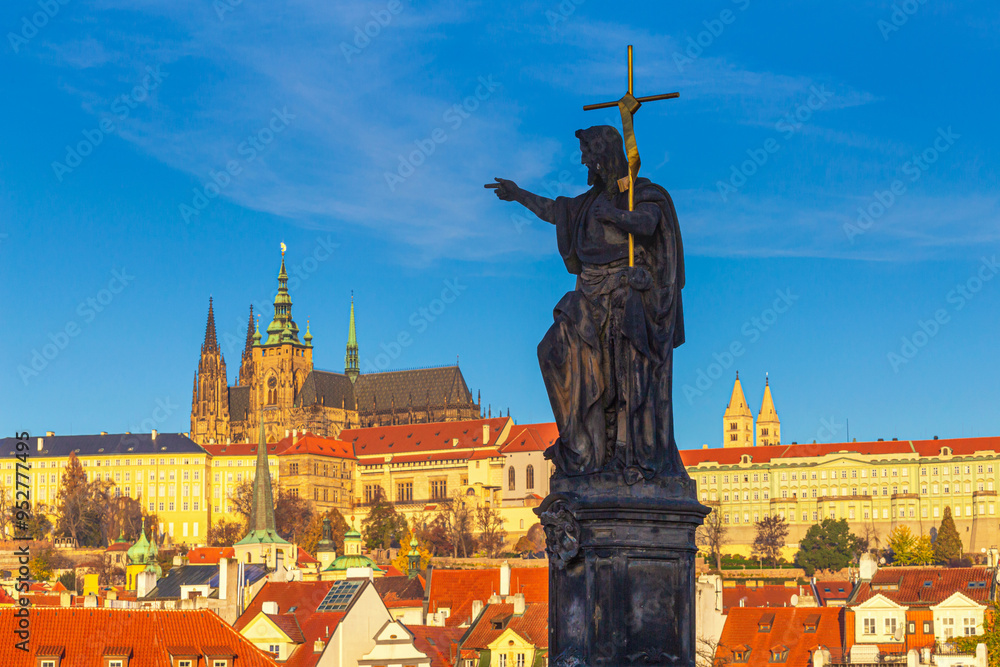 Cityscape - view of the sculpture of St. John the Baptist on Charles Bridge with Prague Castle in the background, Czech Republic