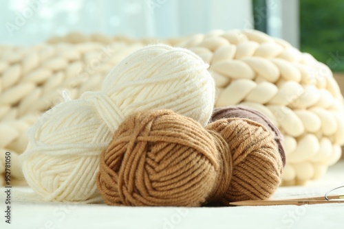 Skeins of yarn and knitting needles on soft blanket, closeup