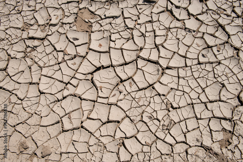 Overhead view of dry, cracked soil. Drought conditions have caused water to recede on a riverbed, creating arid conditions in the soil. Overhead view of dry, cracked soil. Drought conditions have caused water to recede on a riverbed, creating arid conditions in the soil.