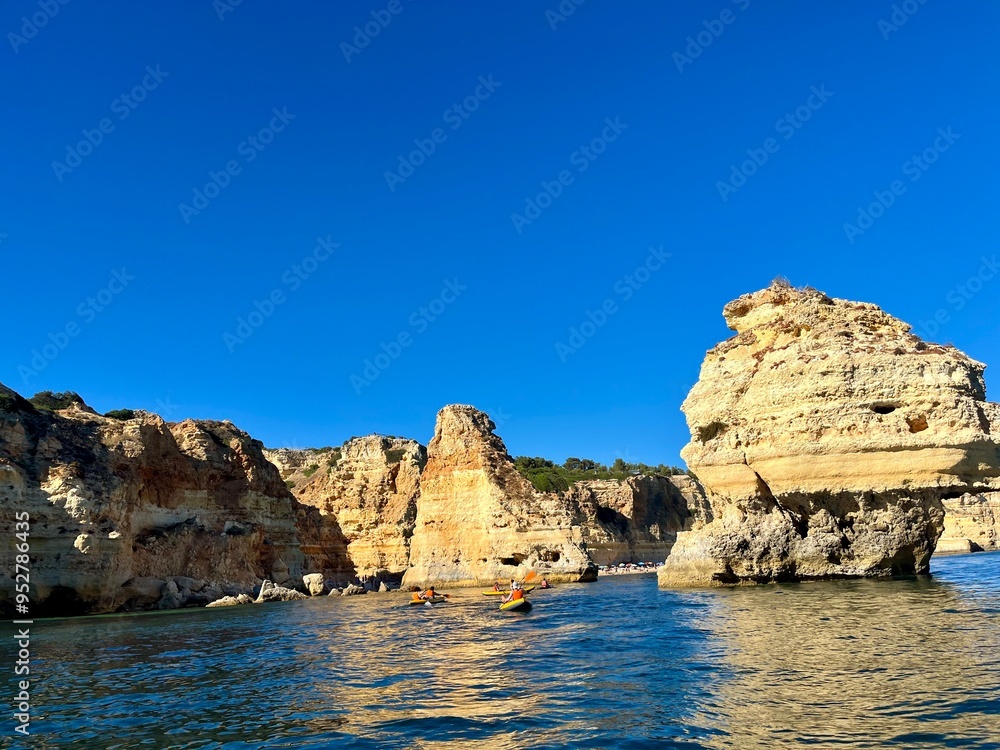 Fototapeta premium Oddly shaped jagged rock formations and cliffs at Lagoa Beach, Faro District, Southern Portugal.