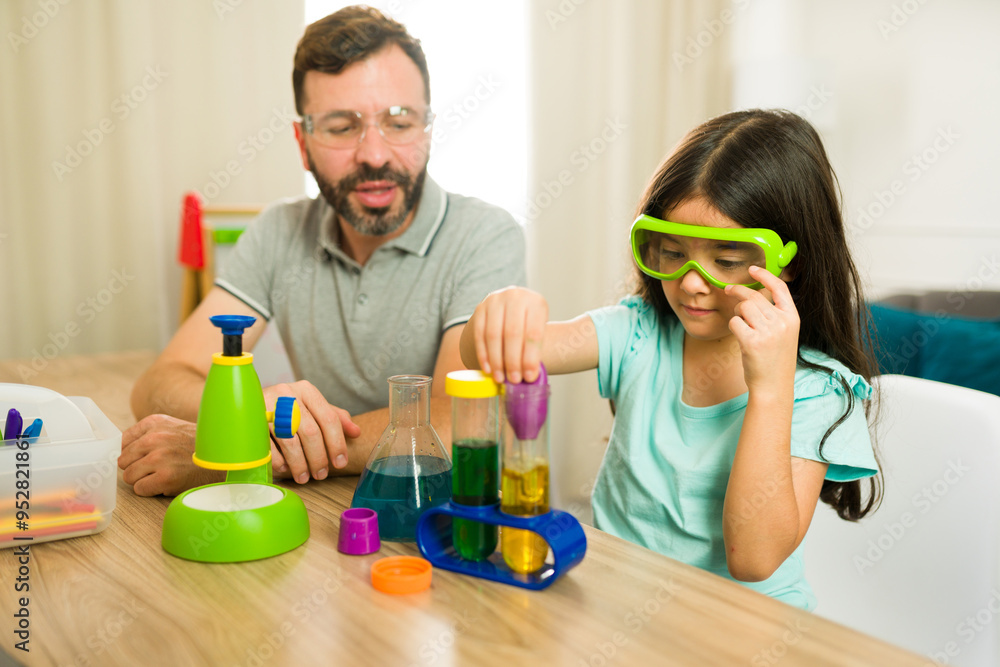 Young girl in safety glasses conducts colorful liquid experiment as part of homeschool science lesson Young girl in safety glasses conducts colorful liquid experiment as part of homeschool science lesson