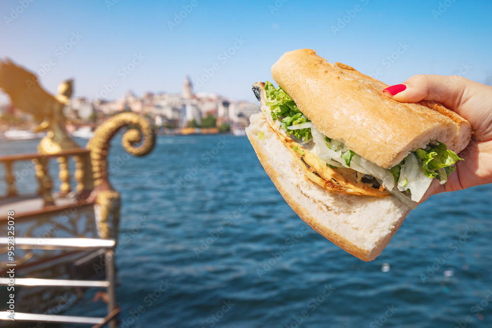 A lively scene at a boat restaurant in Istanbul, where visitors savor balik ekmek while enjoying views of the Bosphorus and city skyline.