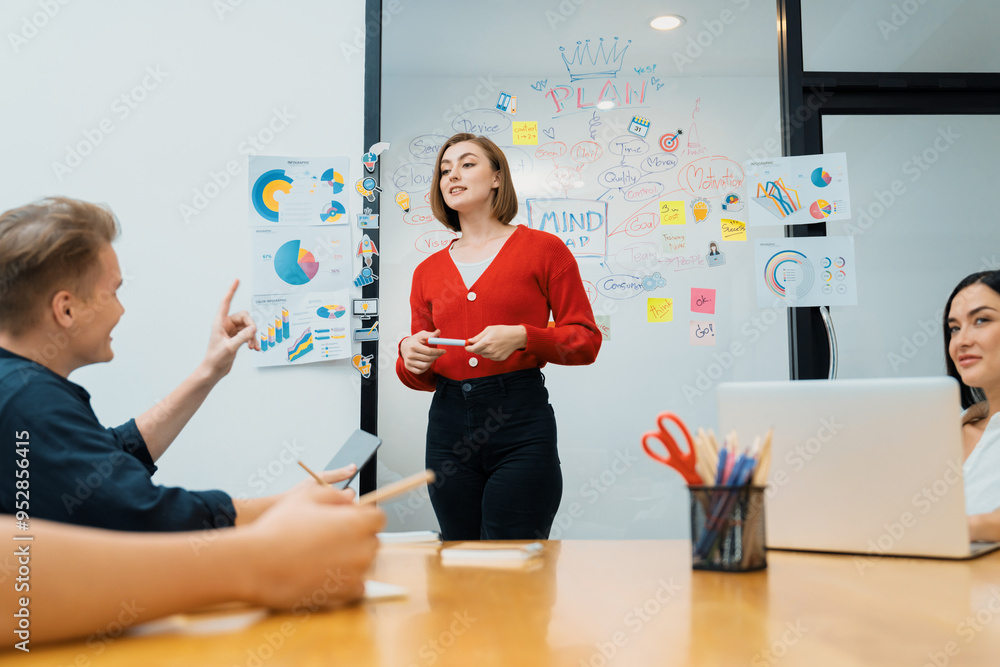 Professional attractive female leader presents creative marketing plan by using brainstorming mind mapping statistic graph and colorful sticky note at modern business meeting room. Immaculate.