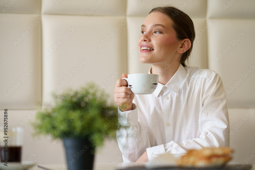 Happy businesswoman enjoying morning coffee in a chic cafeteria Happy businesswoman enjoying morning coffee in a chic cafeteria