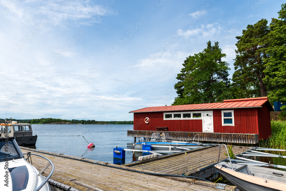 traditional red wooden fisherman's house with white door and windows on the Swedish archipelago at the water's edge traditional red wooden fisherman's house with white door and windows on the Swedish archipelago at the water's edge