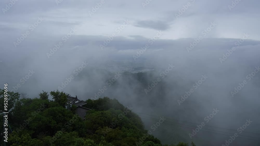 Dense fog, mist, or clouds blanket the valley below, with a glimpse of a historic Japanese castle, creating a dramatic and ethereal atmosphere. Mount Kinka in Gifu, Japan. Dense fog, mist, or clouds blanket the valley below, with a glimpse of a historic Japanese castle, creating a dramatic and ethereal atmosphere. Mount Kinka in Gifu, Japan.