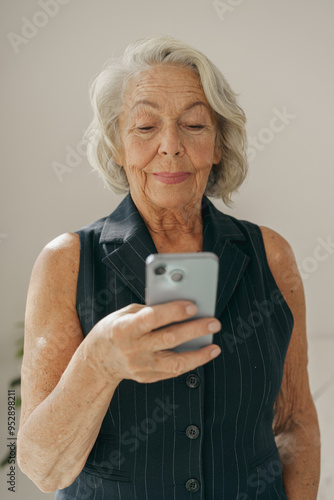 Wallpaper Mural A graceful elderly woman adeptly using her smartphone, illustrating the significant role of technology in daily life Torontodigital.ca
