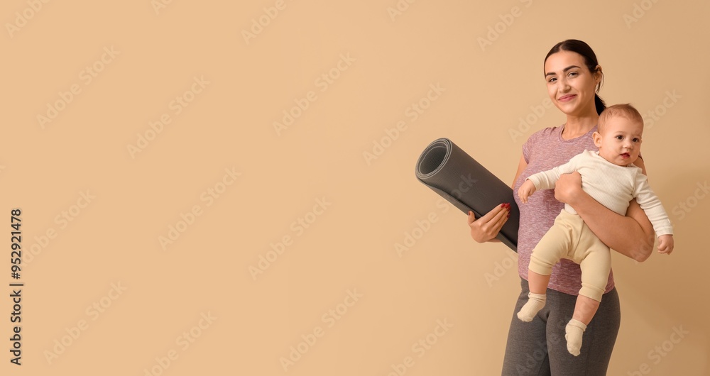 Young sporty woman with yoga mat holding her little baby on beige background with space for text Young sporty woman with yoga mat holding her little baby on beige background with space for text