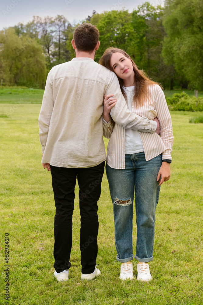 Beautiful loving couple hugging and walking in park on spring day Beautiful loving couple hugging and walking in park on spring day