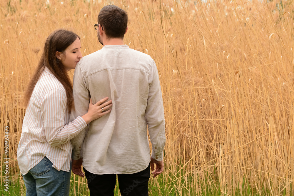 Beautiful happy loving couple hugging in field on spring day Beautiful happy loving couple hugging in field on spring day