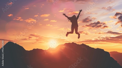 Silhouette of a Woman Jumping on a Mountain at Sunset