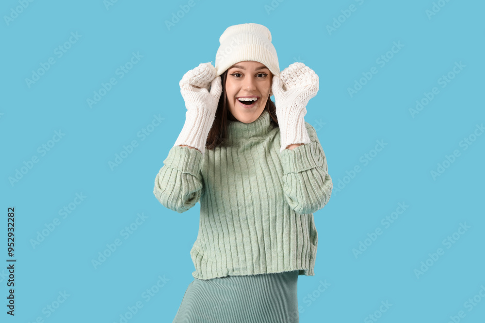 Young woman in winter clothes on blue background Young woman in winter clothes on blue background