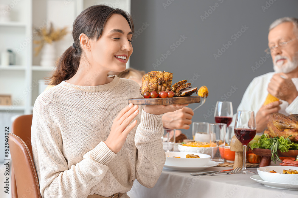 Young woman having family dinner at festive table on Thanksgiving Day Young woman having family dinner at festive table on Thanksgiving Day