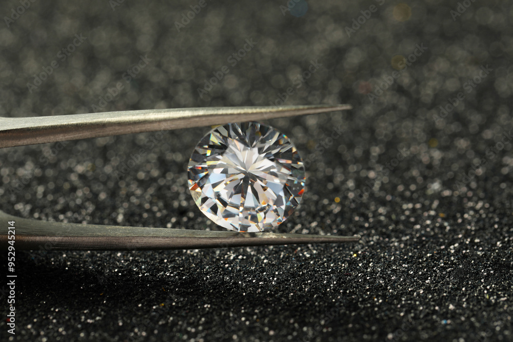 Tweezers with beautiful diamond on dark shiny background, closeup Tweezers with beautiful diamond on dark shiny background, closeup