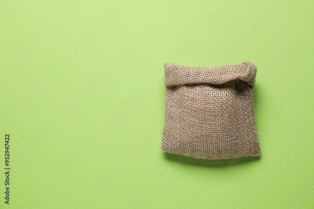One burlap sack on light green background, top view. Space for text One burlap sack on light green background, top view. Space for text