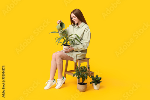 Pretty young woman watering...