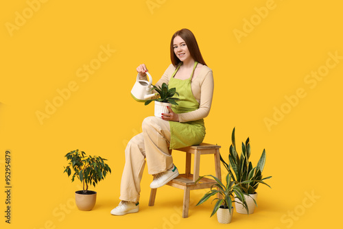 Pretty young woman watering...