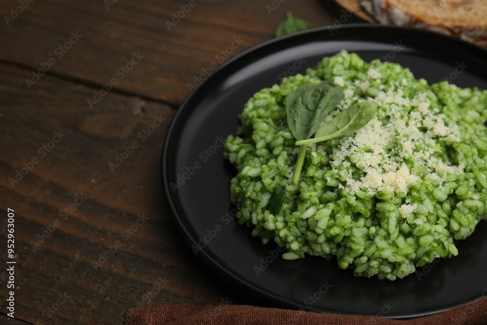 Delicious spinach risotto with parmesan cheese on wooden table, closeup. Space for text Delicious spinach risotto with parmesan cheese on wooden table, closeup. Space for text