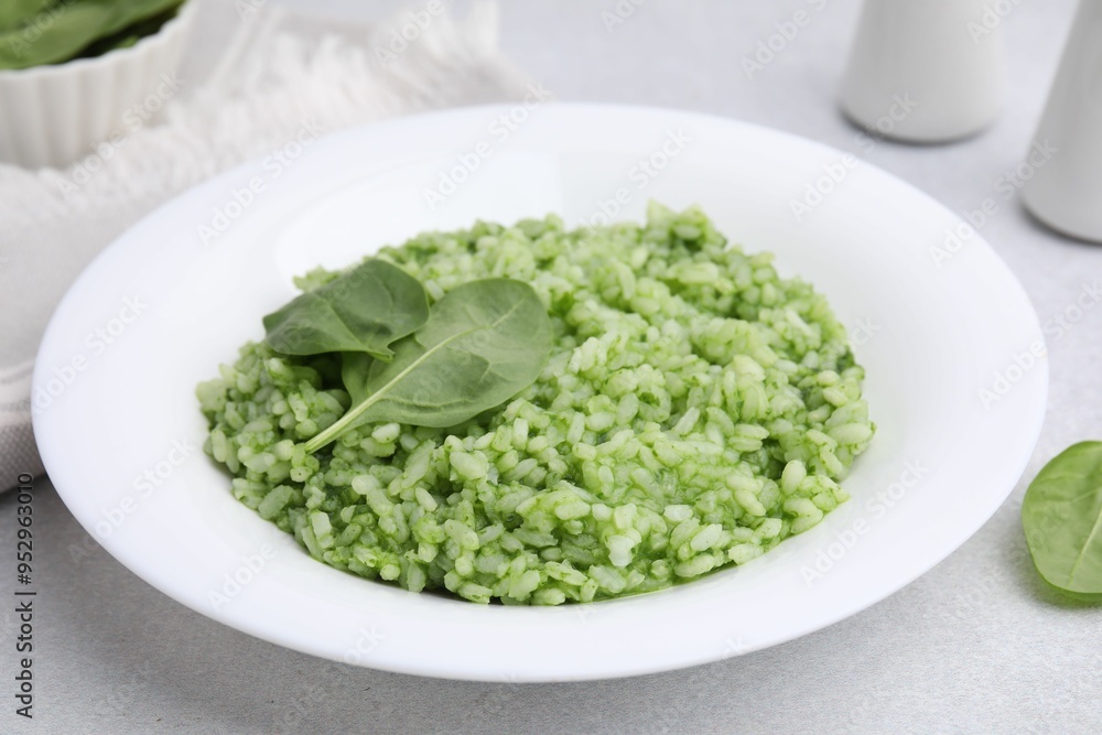 Delicious spinach risotto on light grey table, closeup Delicious spinach risotto on light grey table, closeup