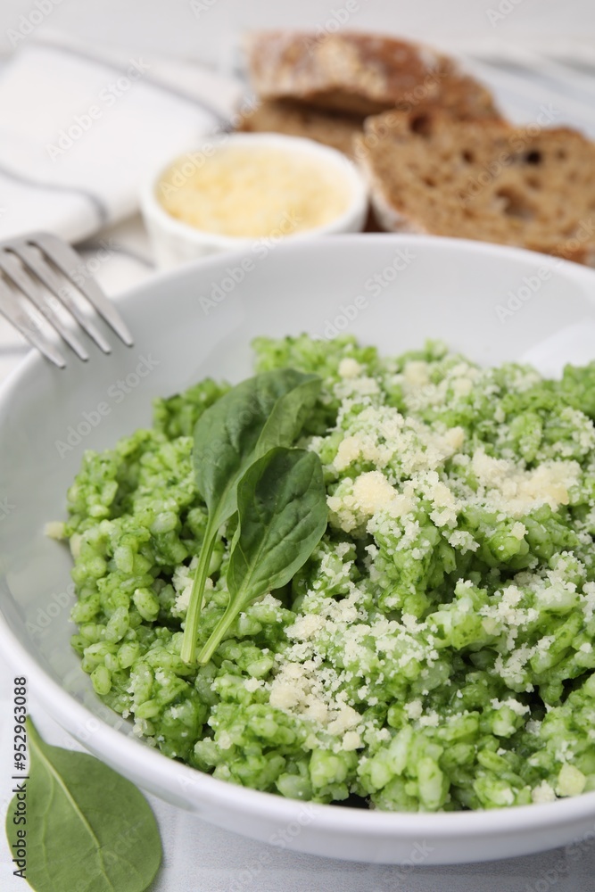 Delicious spinach risotto with parmesan cheese served on white tiled table, closeup Delicious spinach risotto with parmesan cheese served on white tiled table, closeup