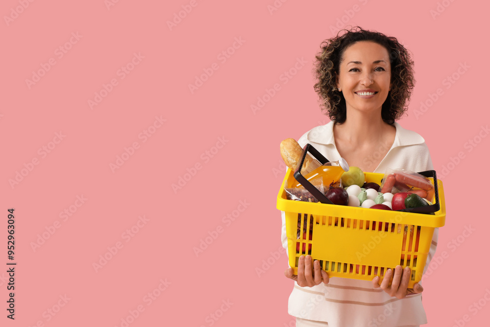 Mature woman with full shopping basket on pink background Mature woman with full shopping basket on pink background