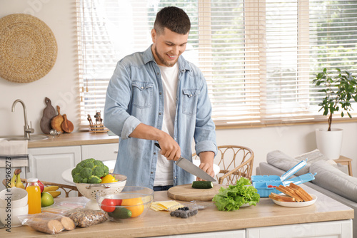 Young man cutting vegetable...