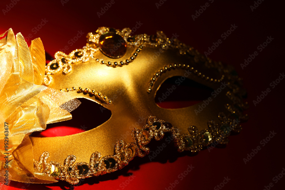 Naklejka premium Beautiful golden carnival mask on red background, closeup