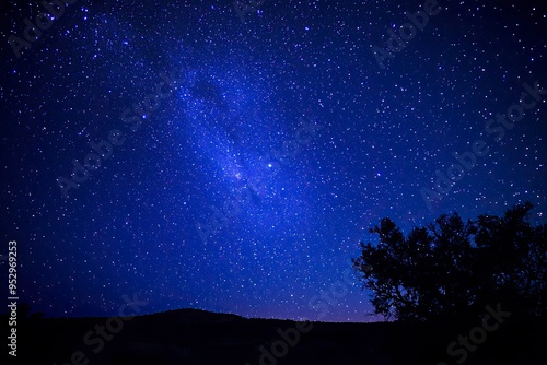 A stunning natural spectacle, often seen in remote areas with minimal light pollution, where countless stars create a breathtaking celestial display against the deep blue night sky, ai