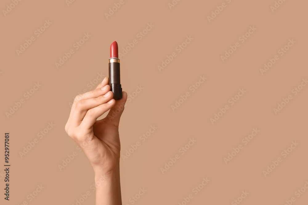 Female hand with lipstick on brown background Female hand with lipstick on brown background