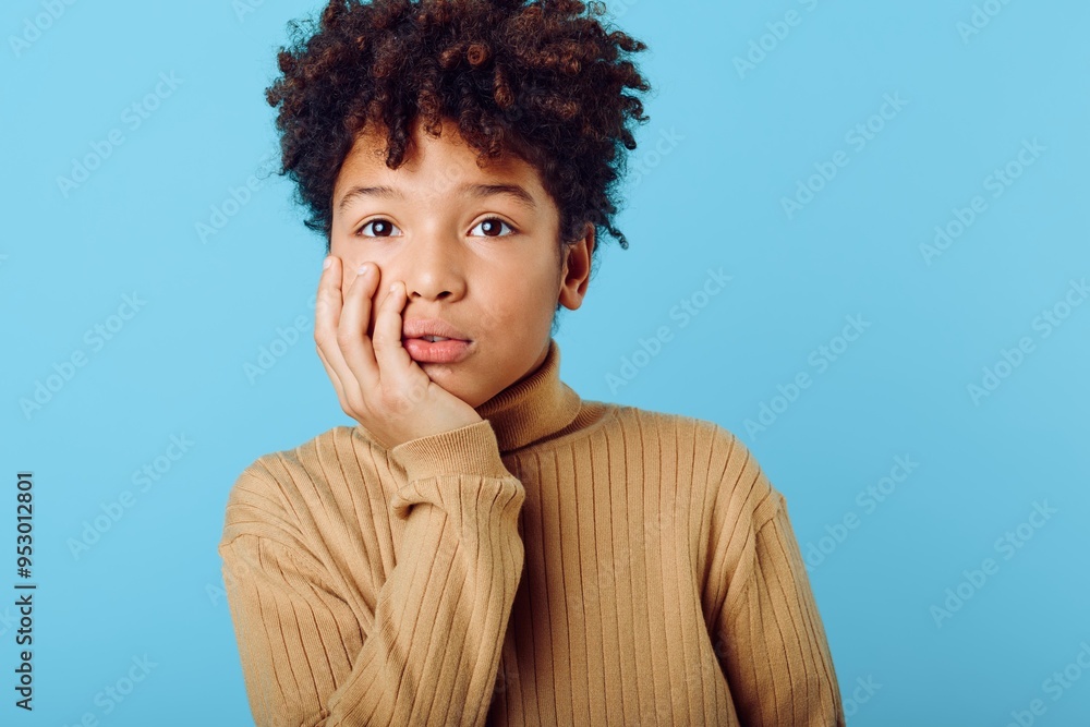 A young african american girl gazing intently at the camera with a thoughtful expression and hand on her face A young african american girl gazing intently at the camera with a thoughtful expression and hand on her face