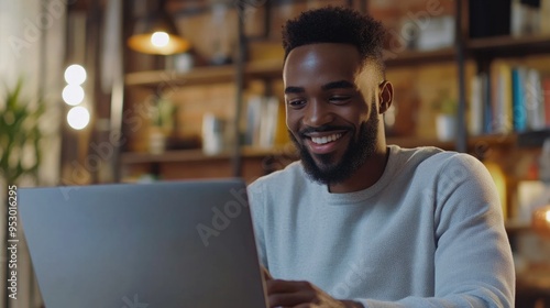 Smiling Man Using Laptop in Library