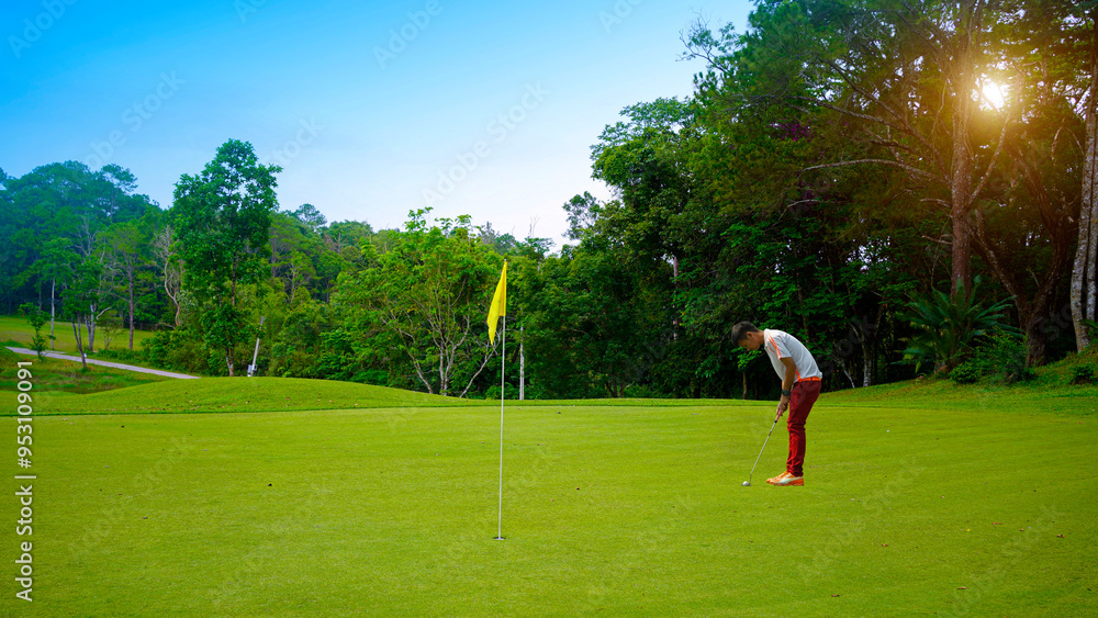 Obraz premium Golfer putting golf in beautiful golf course in the evening golf course with sunshine.