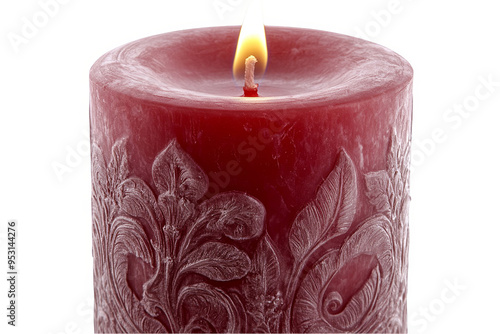 A single, red, pillar candle with an ornate, white floral design and a lit wick.