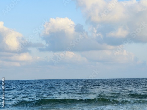 The Mediterranean Sea with blue cloudy sky at sunrise time in Alexandria Egypt, connected to the Atlantic Ocean, surrounded by the Mediterranean Basin, and almost completely enclosed by land