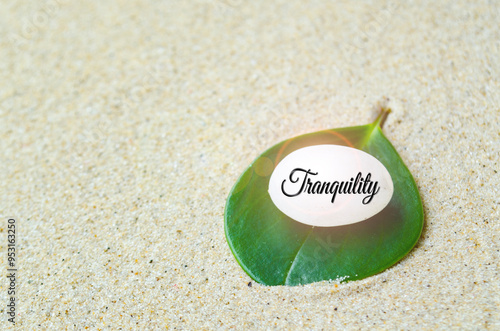 Tranquility text on shining zen stock with beach sand background. Tranquility concept photo