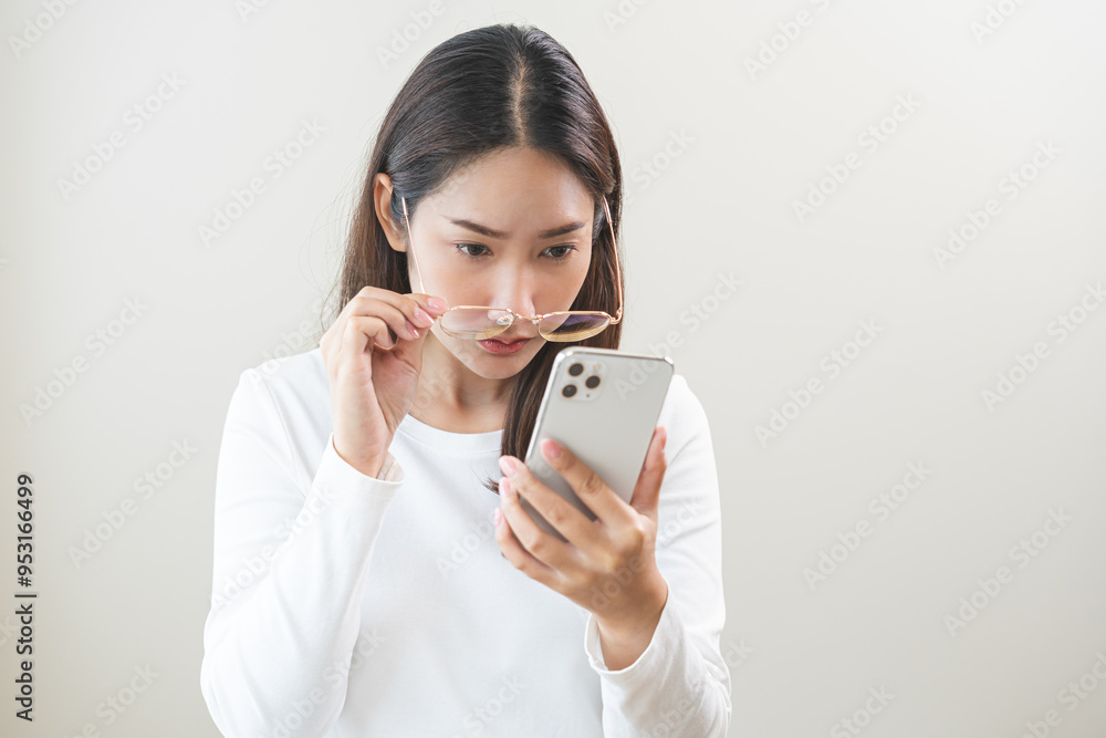 Presbyopia, Hyperopia middle aged asian woman holding eyeglasses problem with vision blurred ,trying to read text message from smart mobile phone screen, eye disease of old, eyesight farsightedness. Presbyopia, Hyperopia middle aged asian woman holding eyeglasses problem with vision blurred ,trying to read text message from smart mobile phone screen, eye disease of old, eyesight farsightedness.