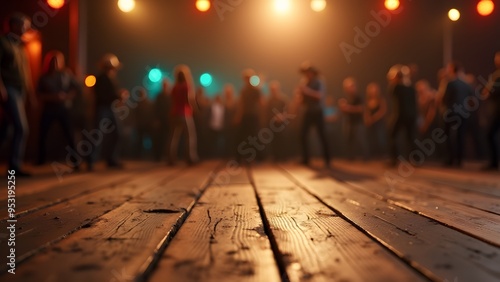 A wooden dance floor in focus with a blurred group of people dancing under warm, festive lighting
