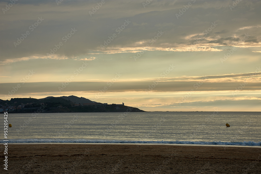 Yellow sunset at playa america in nigran with montereal de bayona in the background Yellow sunset at playa america in nigran with montereal de bayona in the background