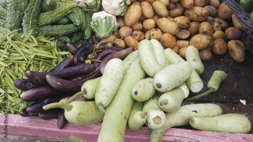 Organic vegetables displayed at a local market, vegetable produce including long bottle goard lauki cauliflower, eggplant, bitter gourd, potatoes, cluster beans, agriculture produce veggies vegetarian