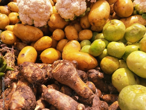 Vegetables displayed at a local market, assorted vegetable produce including cauliflower, potatoes, and taroroot, apple gourd, agriculture produce veggies vegetarian food at market  photo