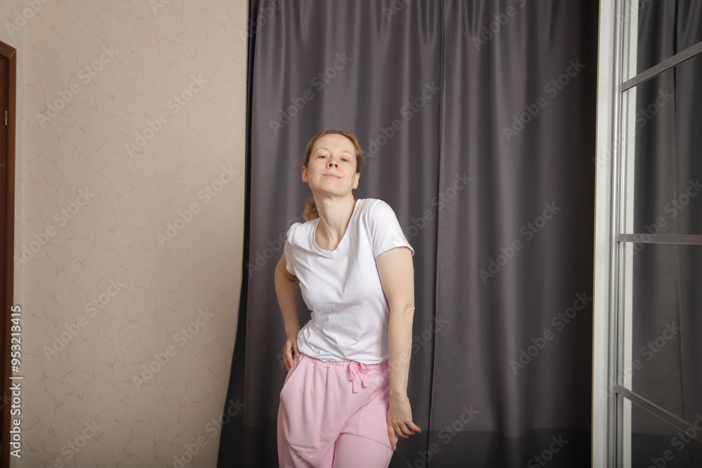 Woman dancing at home, enjoying music while exercising, young person embracing the fun of indoor aerobics. Woman dancing at home, enjoying music while exercising, young person embracing the fun of indoor aerobics.