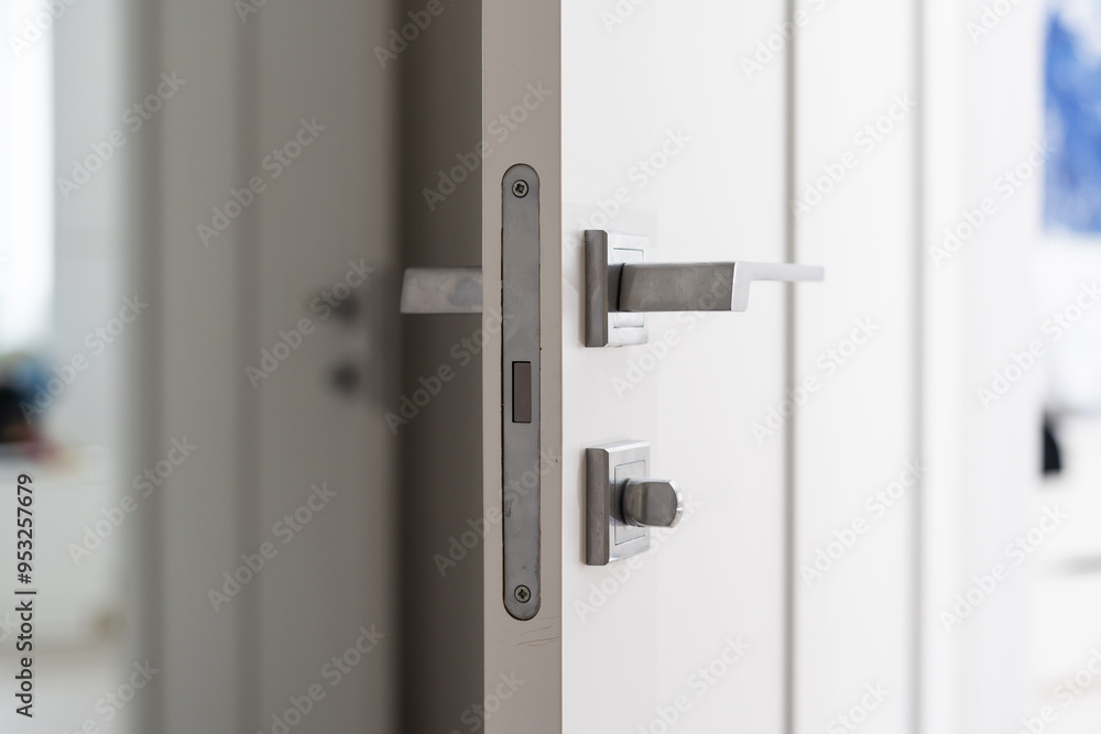 Modern white door with matte black handle and magnetic locks, lock with insert key. Modern white door with matte black handle and magnetic locks, lock with insert key.