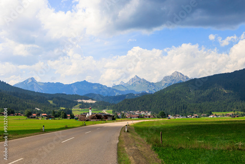 View over a road to the village of Heiterwang in Austria on a summer day with cumulus clouds photo