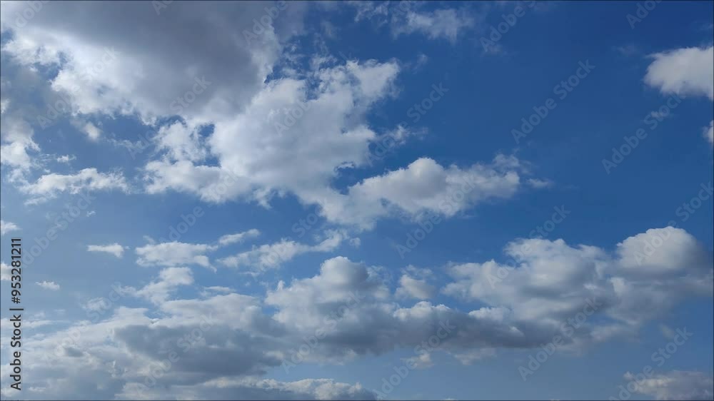 Small cumulus clouds move across the bright sky in the afternoon Small cumulus clouds move across the bright sky in the afternoon