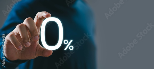 Foto A person in a dark shirt touches a glowing 0% sign, representing zero percent, offers, discounts, promotions, or interest rates on a gray background