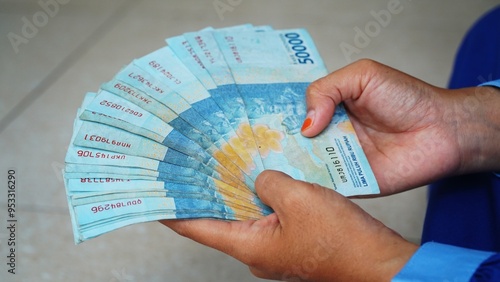 Woman Holding and Showing 50,000 Indonesian Rupiah Money, Indonesian banknote photo