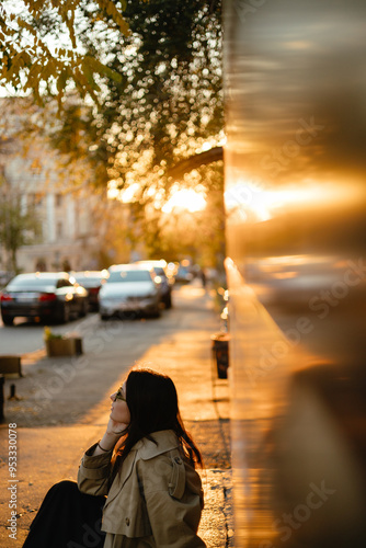 Wallpaper Mural portrait of a stylish girl wearing a beige trench coat and sunglasses against the background of the streets of the autumn city illuminated by the evening sunlight Torontodigital.ca