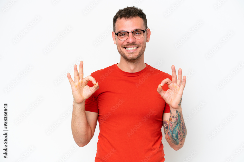 Fototapeta premium Young caucasian handsome man isolated on white background showing ok sign with two hands