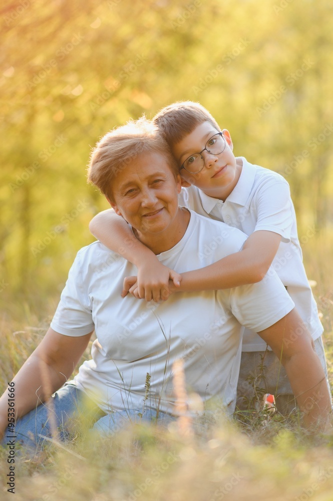 Grandmother walking with her grandson. Relaxing and joying in sunset Grandmother walking with her grandson. Relaxing and joying in sunset